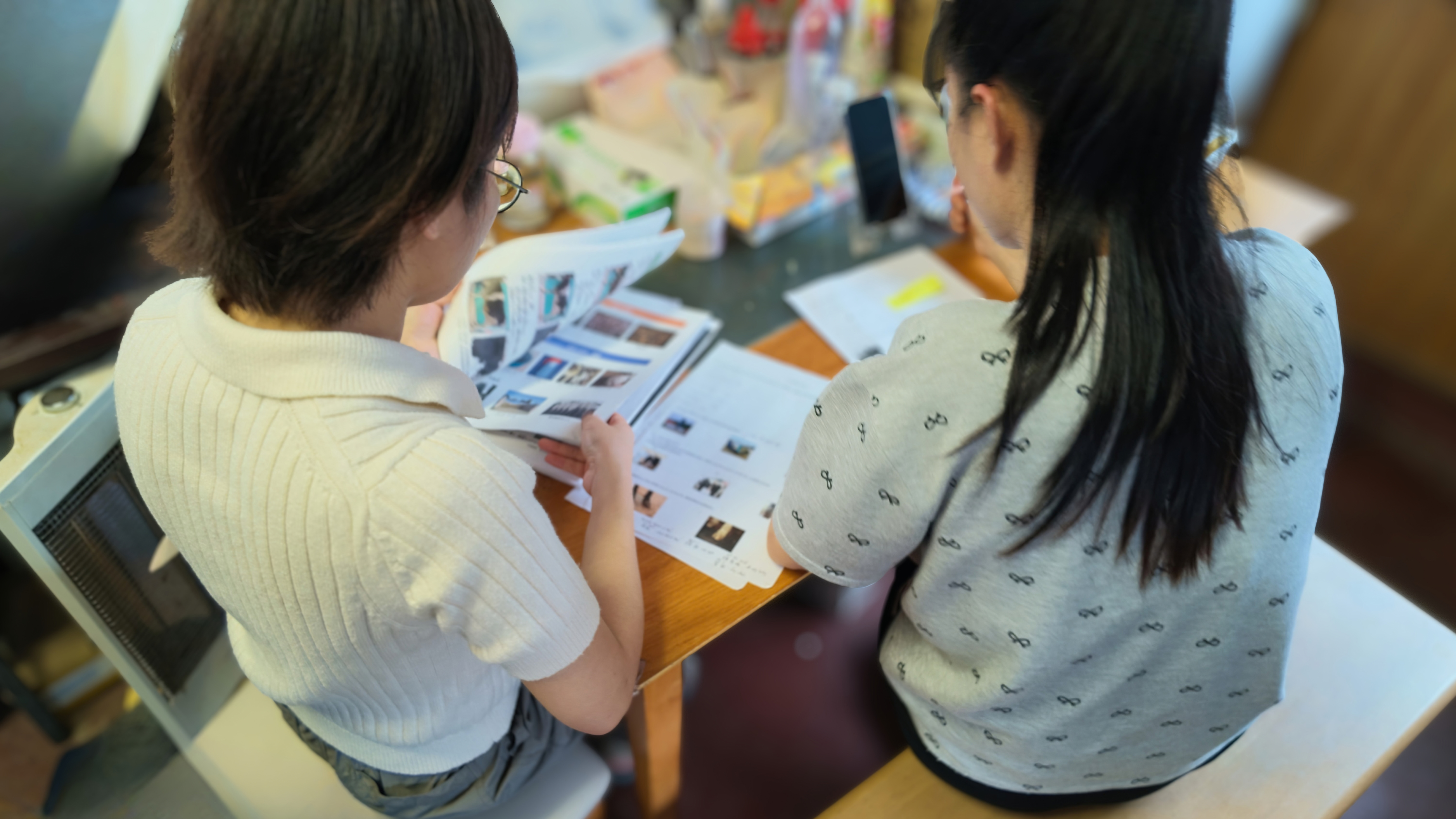 牧場で働く実習生と資料を見ながら基礎級試験の専門用語を確認する様子