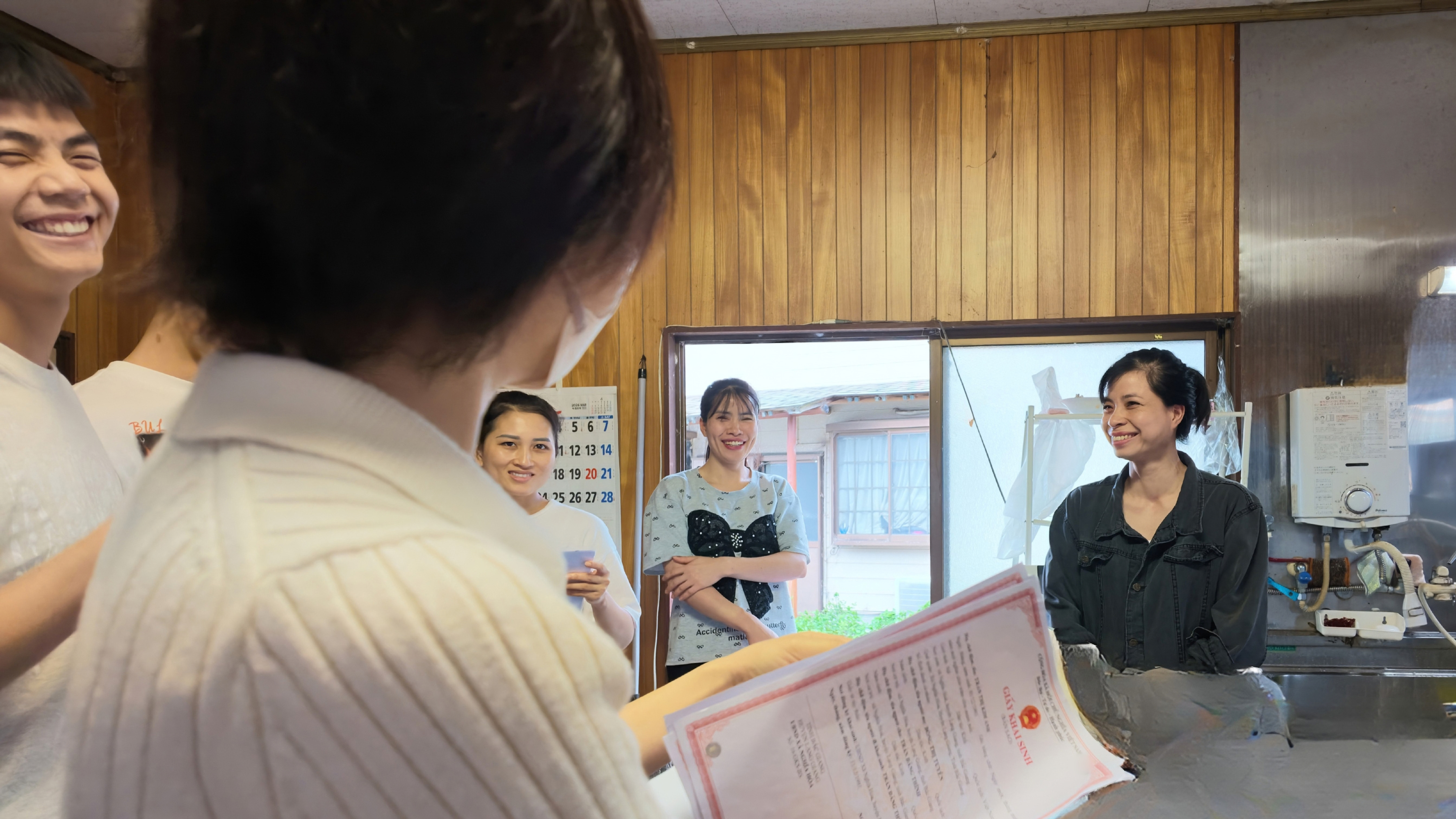 牧場への定期訪問で実習生と話をしながら公的書類を確認する様子