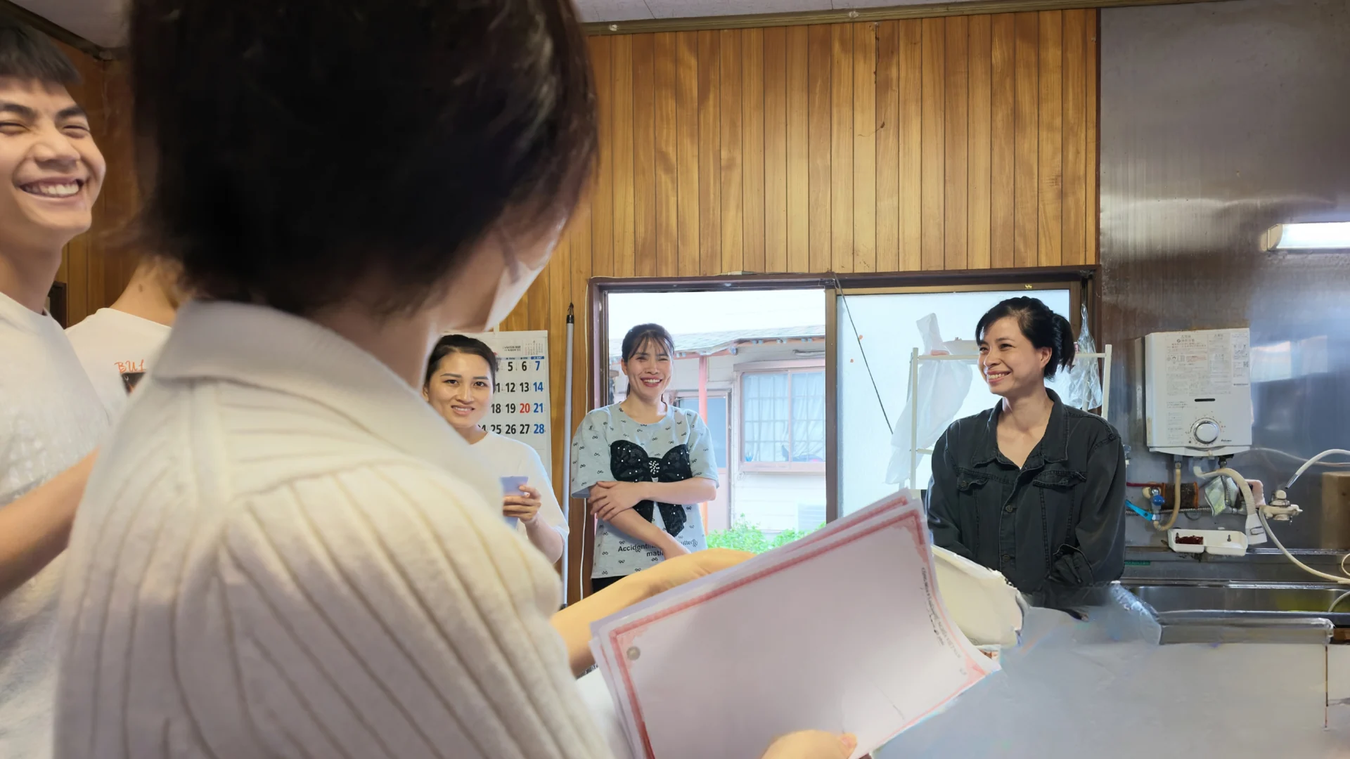 牧場への定期訪問で実習生と話をしながら公的書類を確認する様子